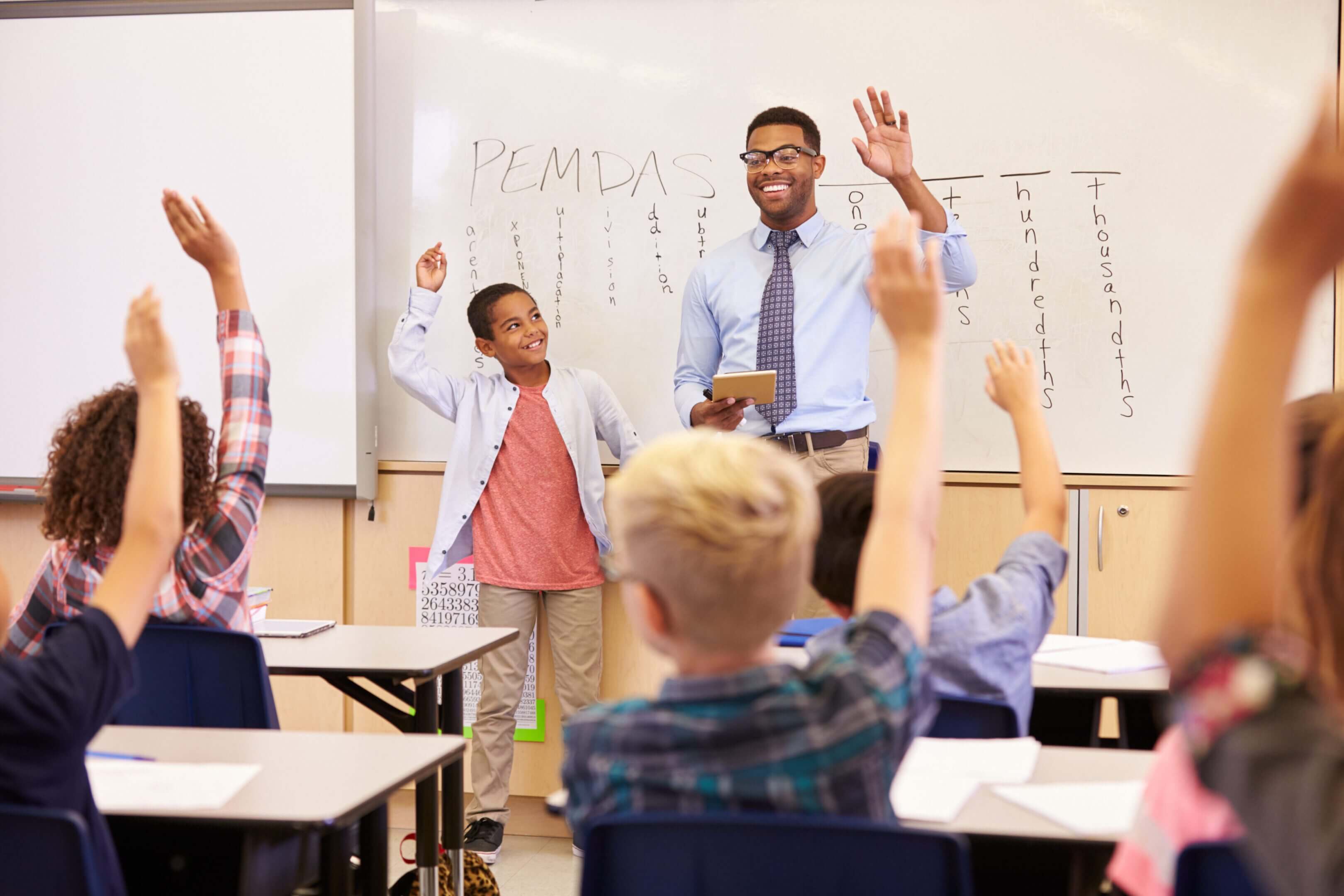 Smiling teacher and student with raised hands